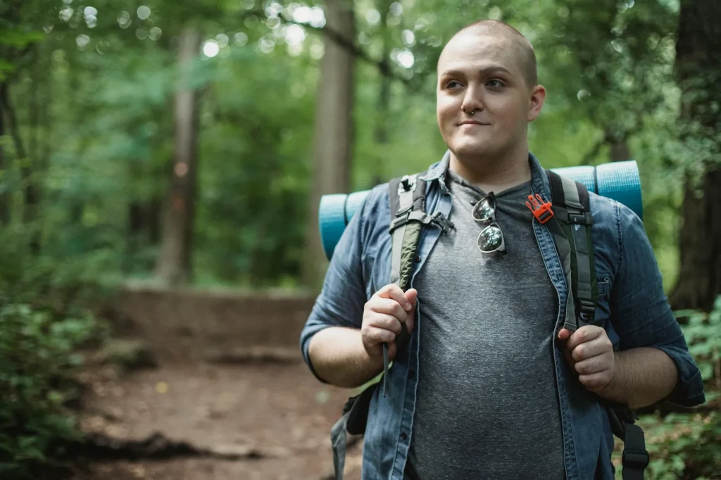 Hiking backpack on a trail surrounded by green hills and countryside