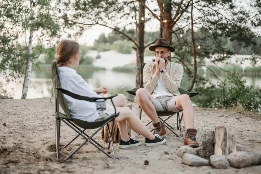 Camping chairs set up around a campfire in the evening