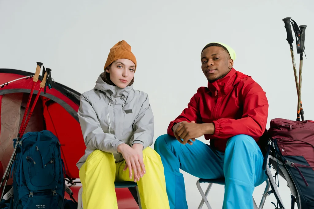 Two hikers in layered winter clothing with backpacks ready for a camping trip