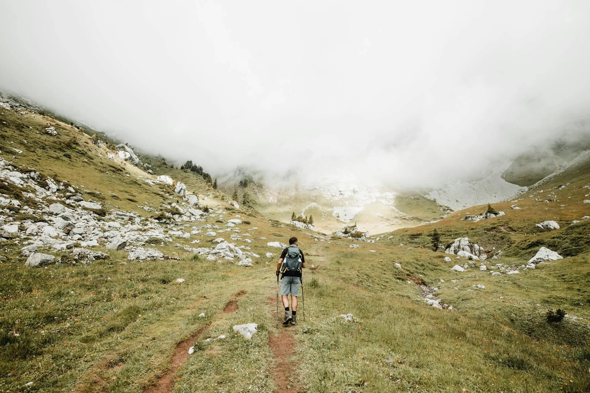 Hiker with a day pack walking along a mountain trail