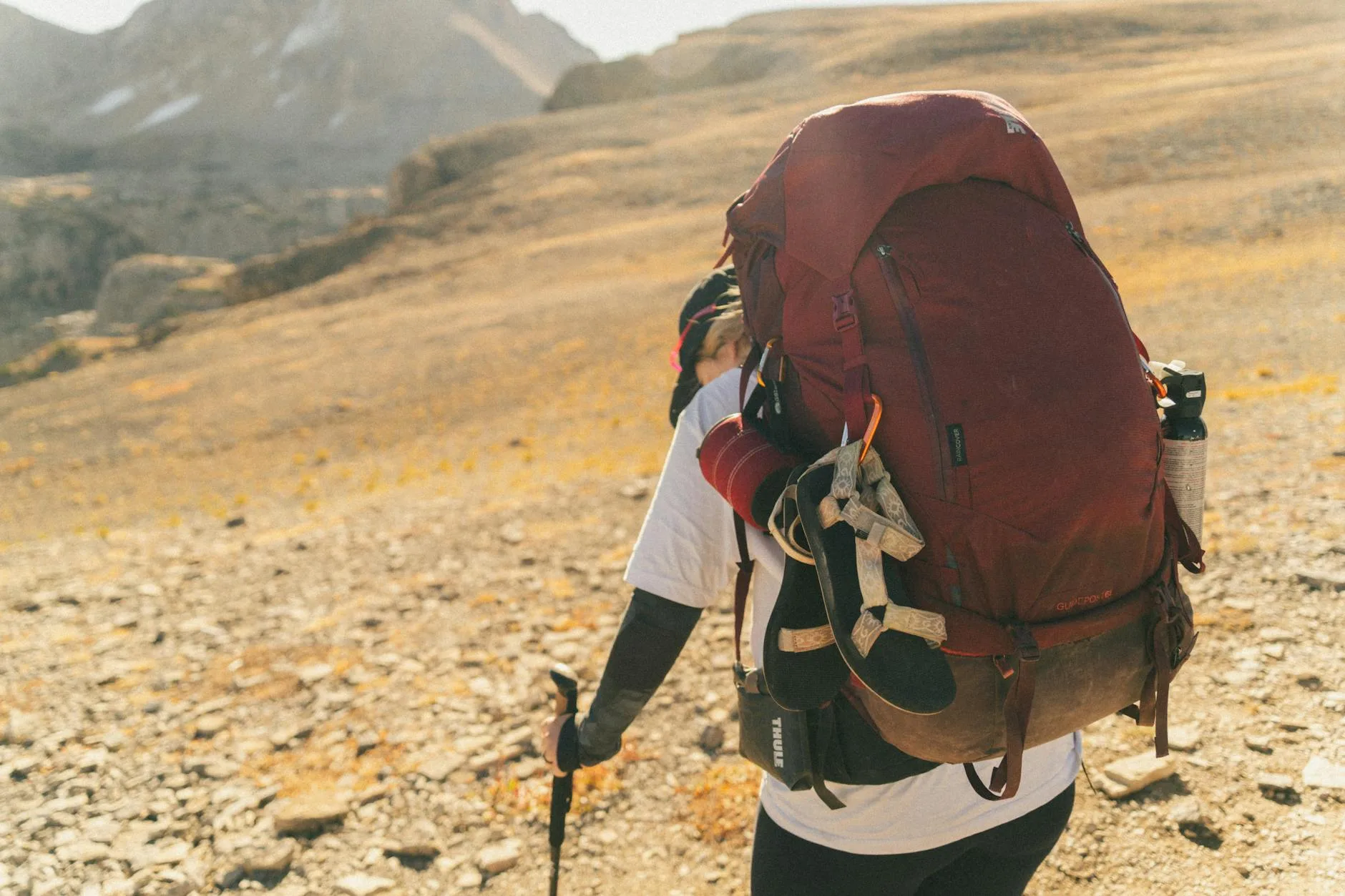 Hiker wearing a large rucksack in a mountain landscape
