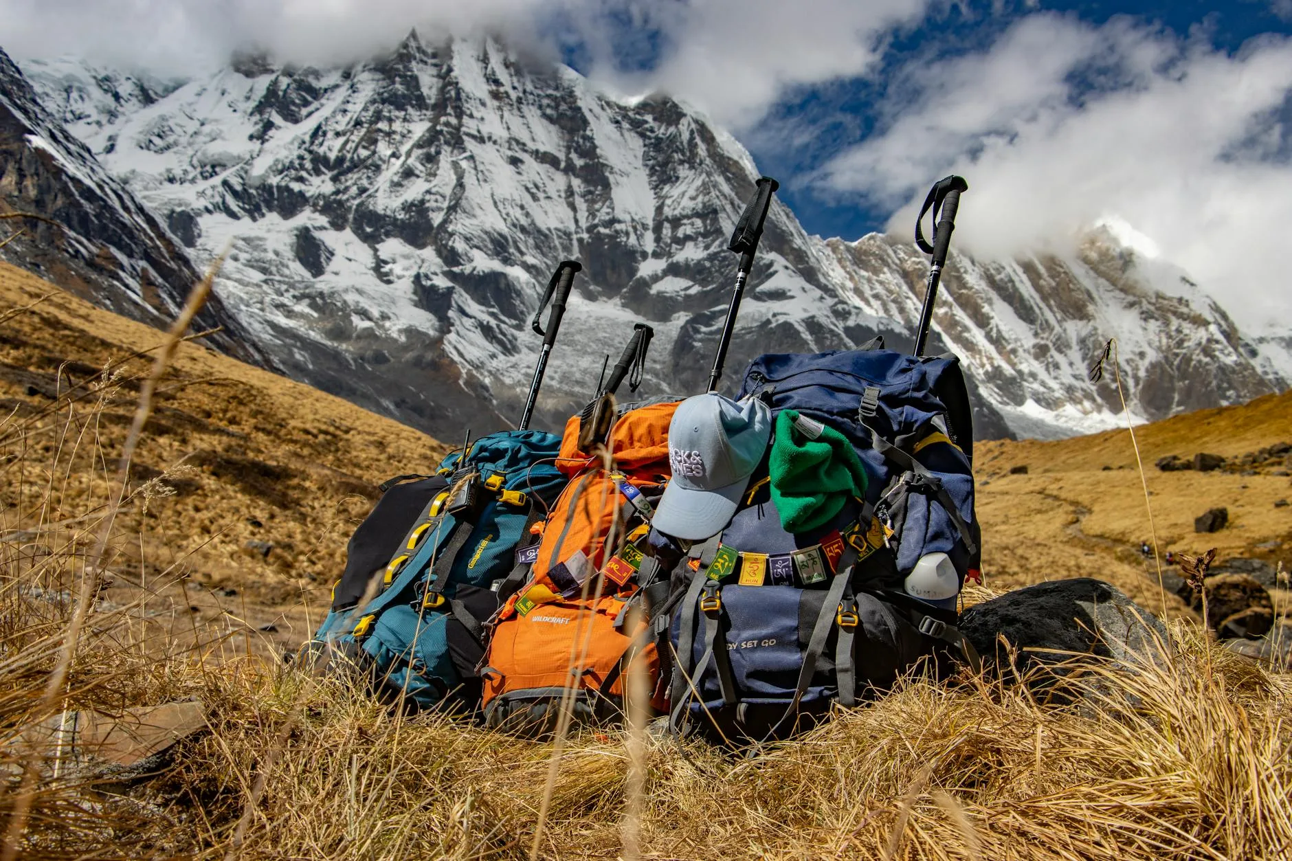 Three hiking rucksacks propped together against a mountain backdrop