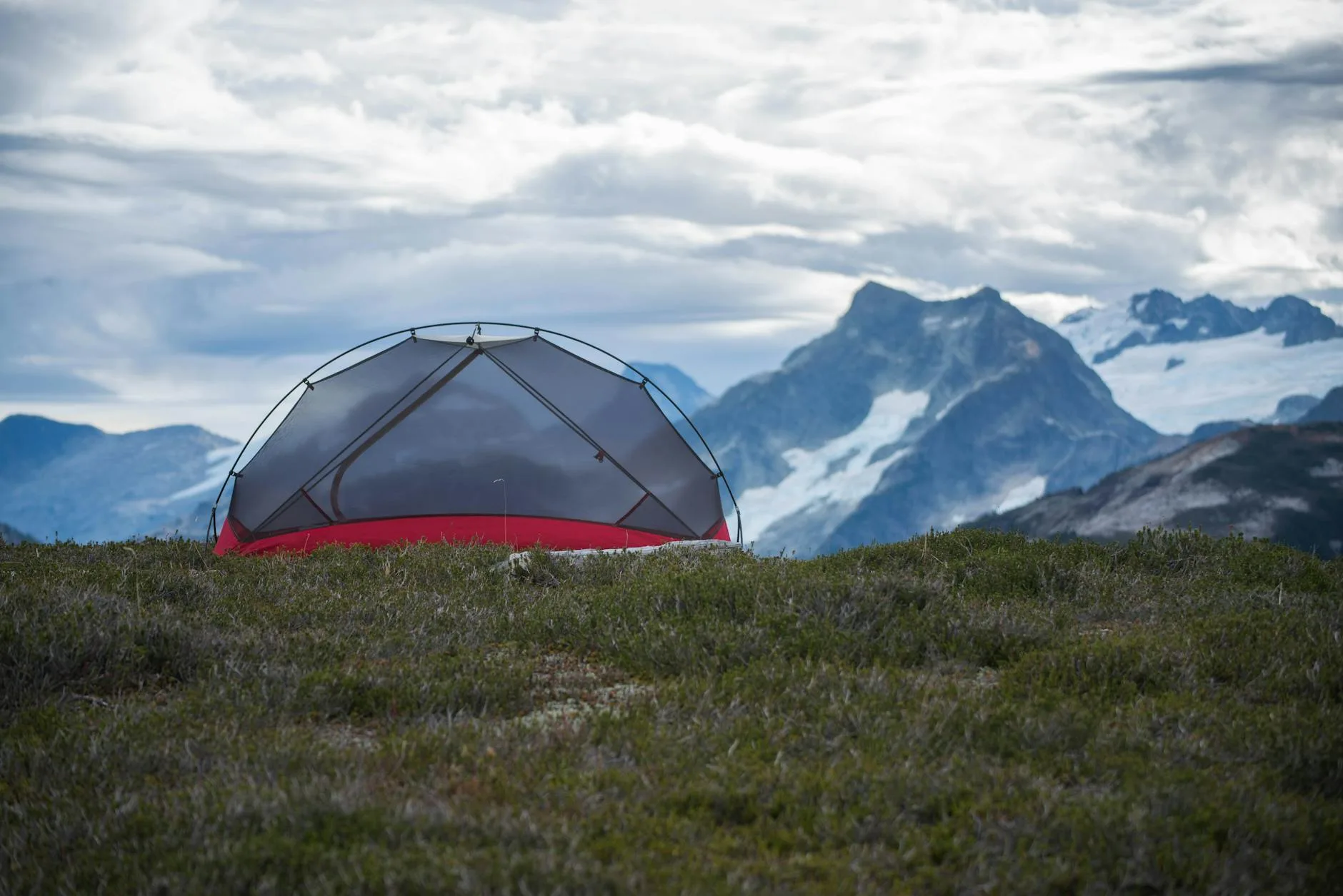 Small tent pitched in a mountain landscape at dawn