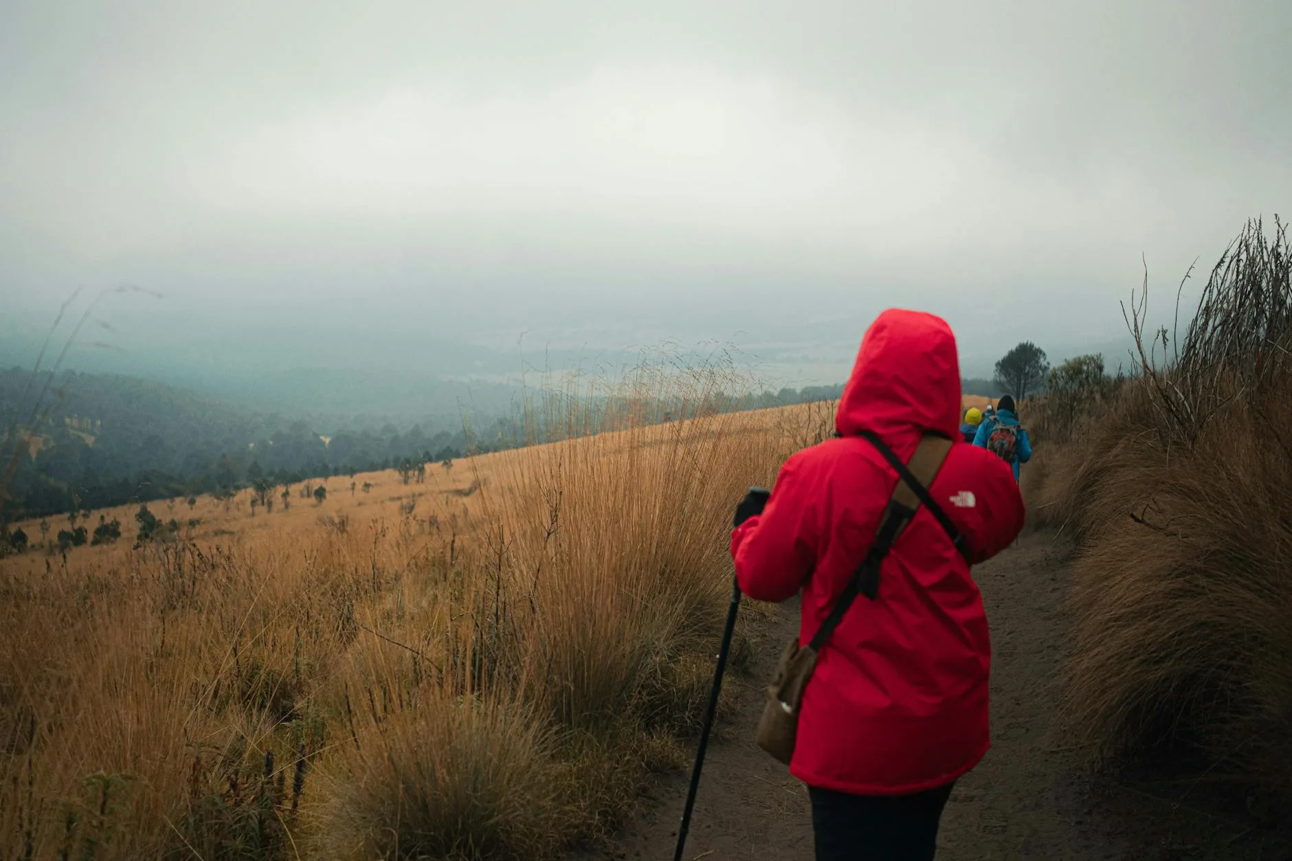 Hiker wearing a waterproof outer layer jacket in rain