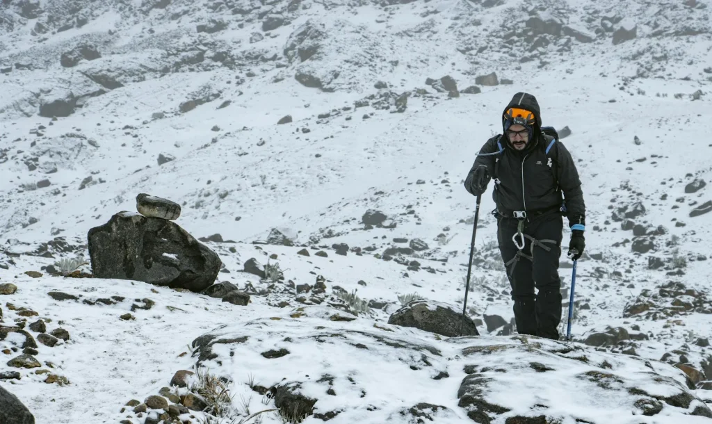 Person wearing a waterproof jacket while hiking in the rain