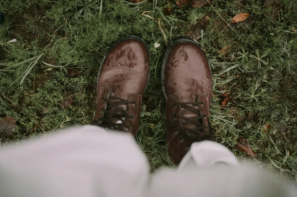 Wet hiking boots on a muddy trail in rainy conditions