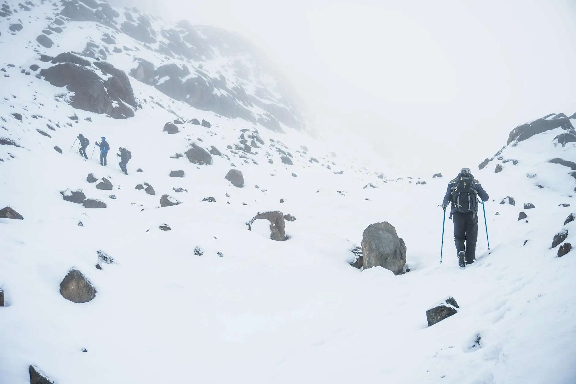 Winter hikers in cold-weather base layers on a snowy mountain
