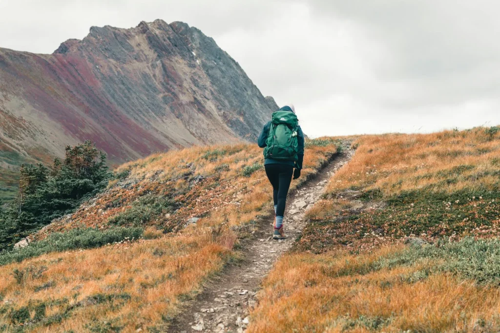 Woman wearing a hiking rucksack on a mountain trail
