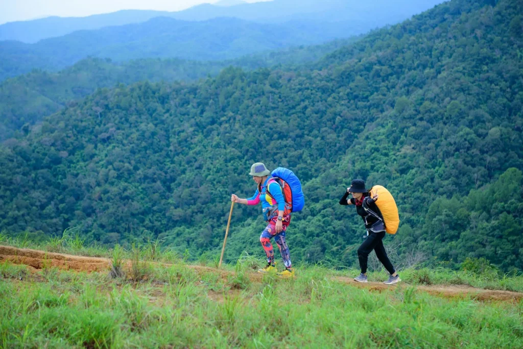 Hiker using trekking poles on a mountain trail