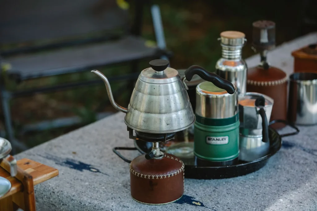 Camping cookware pots and stove arranged on an outdoor table