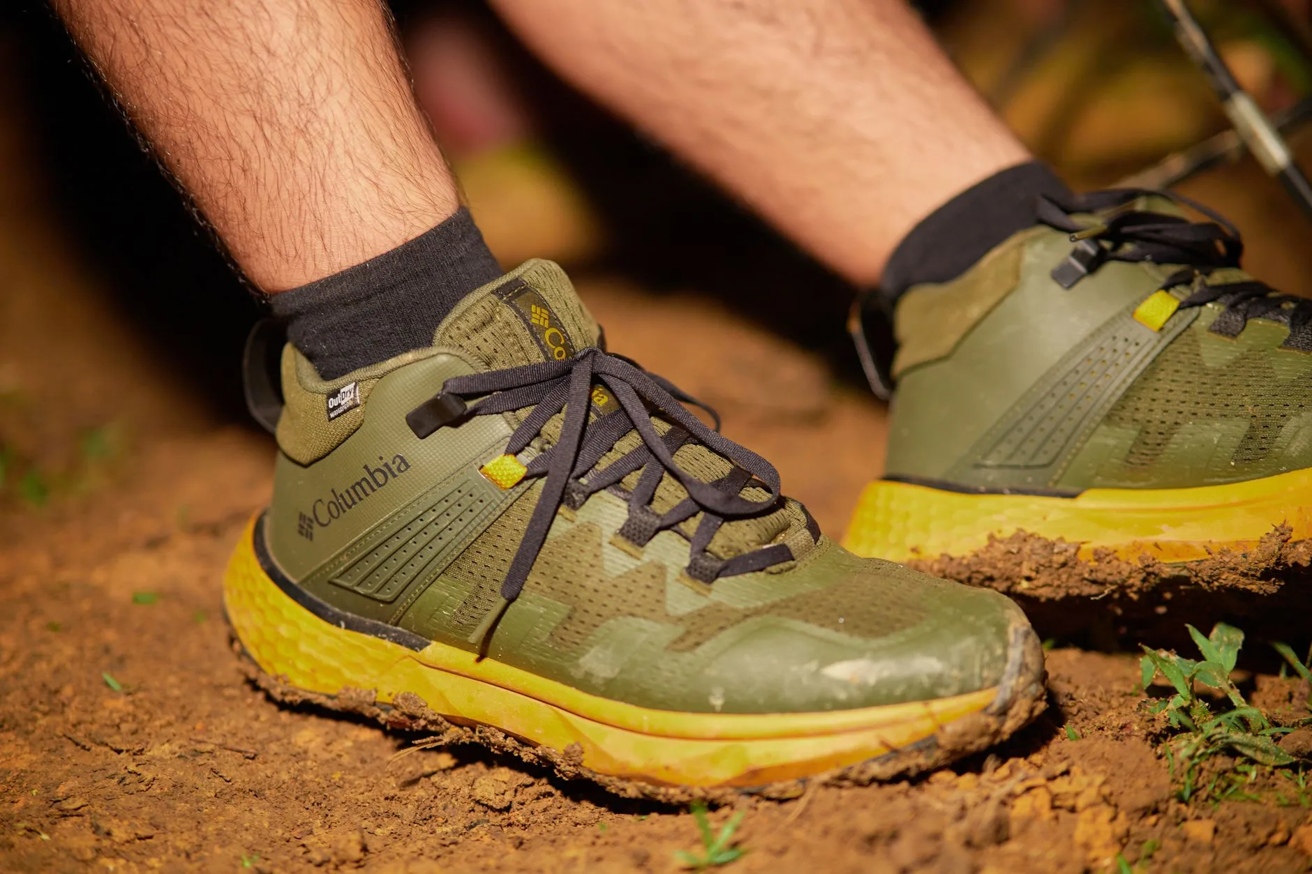 Muddy hiking boots with waterproof trousers on a UK trail