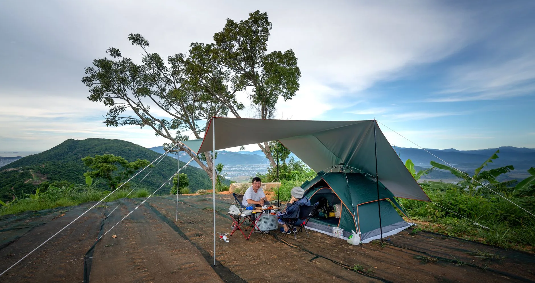 Ultralight tarp shelter pitched with trekking poles at camp