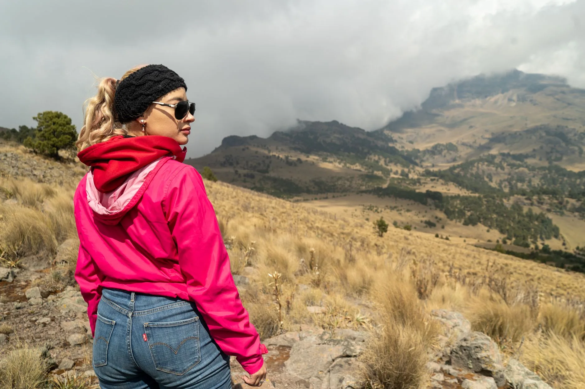 Hiking base layer fleece and waterproof jacket laid out for a walk